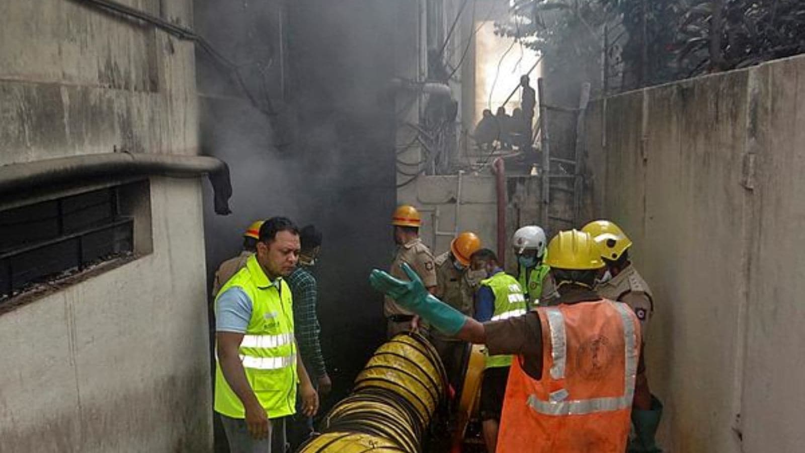Firemen and others during a rescue operation after a fire broke out at the basement of a four-storey commercial building at RT Nagar, in Bengaluru