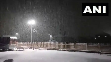 This screengrab from a video shared on social media showed a steady snowfall covering parked vehicles and roads late on Monday. (X/ANI)