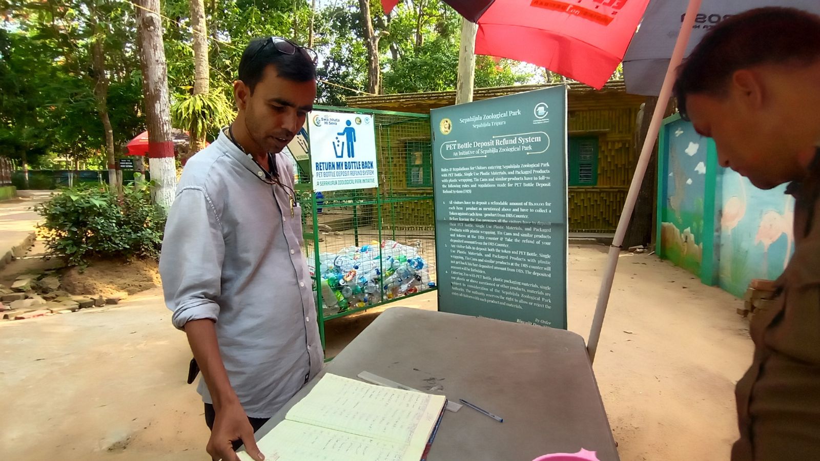 Sepahijala Zoo Director Biswajit Das inspects visitor log book at entry gate.