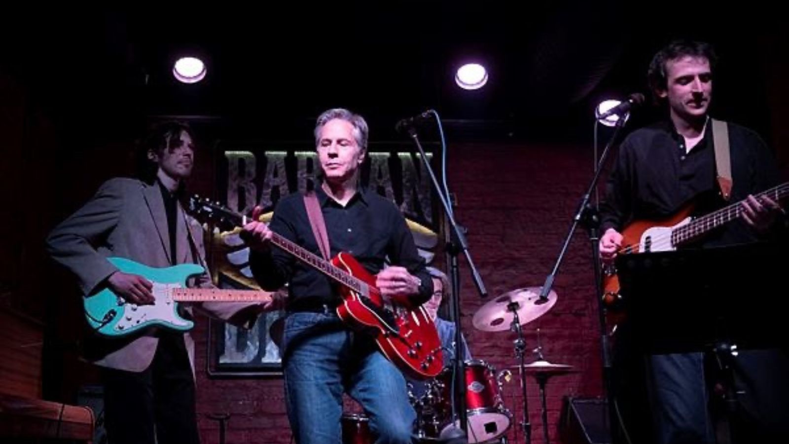 US Secretary of State Antony Blinken, center, performs "Rockin' in the Free World" with members of The 1999 band at the Barman Dictat bar in Kyiv.