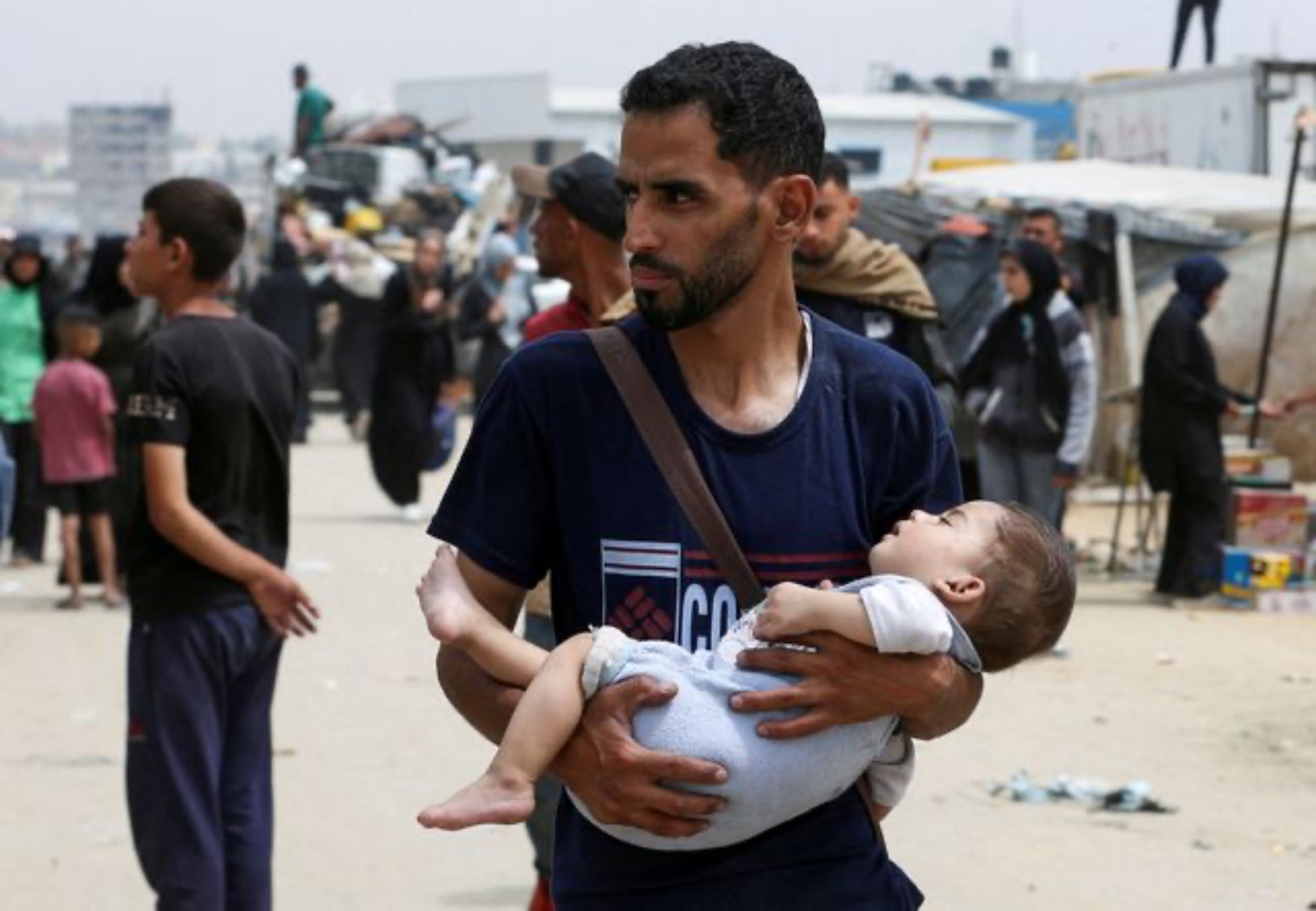 Palestinians travel on foot along with their belongings as they flee Rafah due to an Israeli military operation