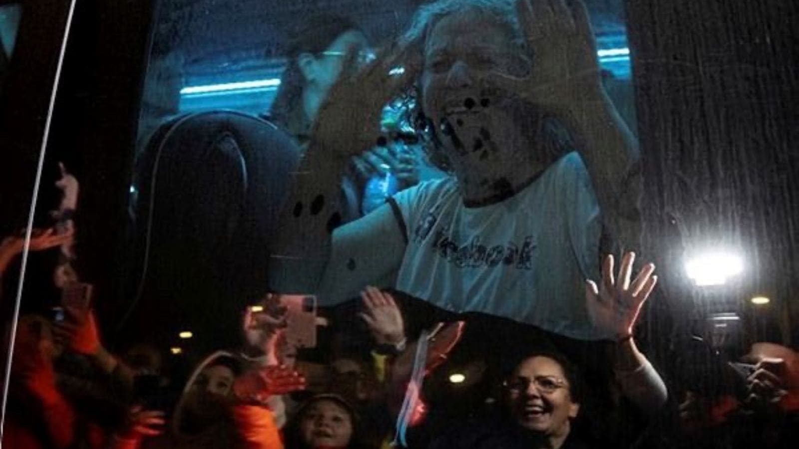 Aviva Adrienne Siegel, 62, who was released after being taken hostage during the October 7 attack on Israel by Hamas, waves to well-wishers from the bus she is traveling in, in Ofakim, Israel. (Reuters Photo)