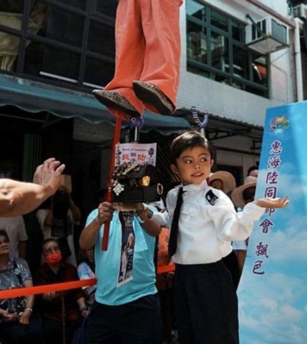 A child is dressed up as a law enforcement officer during the Bun Festival parade at Cheung Chau island. (Reuters Photo)