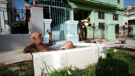 Retired painter Julio Rodriguez, 61, relaxes in a bathtub in front of his home in Havana, Cuba, July 21, 2023.