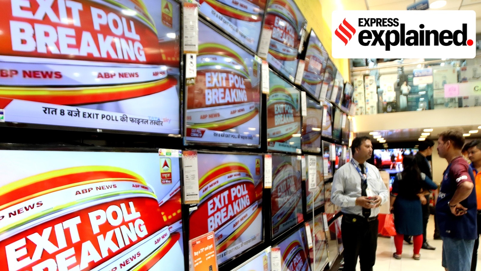 People watch exit poll results at a television retail showroom at Girgaum, Mumbai.
