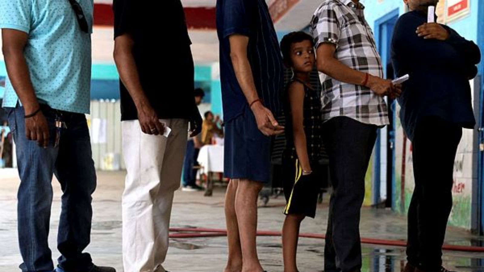 Voters queue at a polling station during the sixth phase of the general election