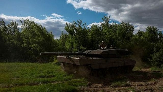 Ukrainian servicemen of the 21st Separate Mechanized Brigade ride atop of a Leopard 2A6 tank, amid Russia's attack on Ukraine, near a front line in Donetsk region, Ukraine