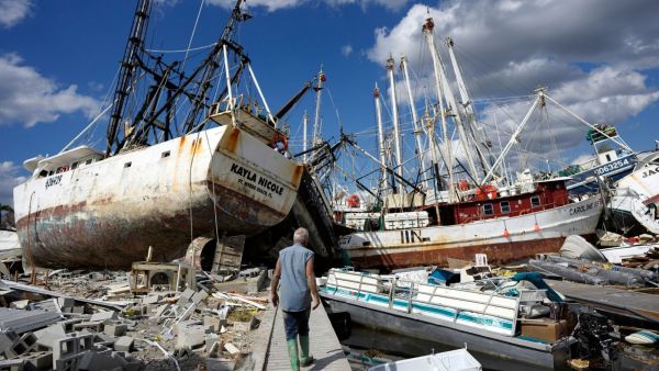 Bruce Hickey, 70, walks along the waterfront, now littered with debris including shrimp boats, in the mobile home park where he and his wife, Kathy, have a winter home on San Carlos Island, Fort Myers Beach, Fla., on Oct. 5, 2022, one week after the passage of Hurricane Ian. The National Oceanic Atmospheric Administration Thursday, June 13, 2024, pronounced dead the El Nino that warms parts of the central Pacific. Forecasters expect La Nina to breeze in just in time for peak Atlantic hurricane season. (AP Photo/Rebecca Blackwell, File)