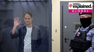 Wall Street Journal reporter Evan Gershkovich, who is in custody on espionage charges, waves behind a glass wall of an enclosure for defendants as he attends a court hearing in Moscow, Russia, April 23, 2024.