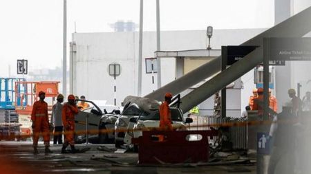 Members of the National Disaster Response Force investigate vehicles that were damaged after a portion of a canopy collapsed following heavy rainfall, at the Indira Gandhi International Airport in New Delhi