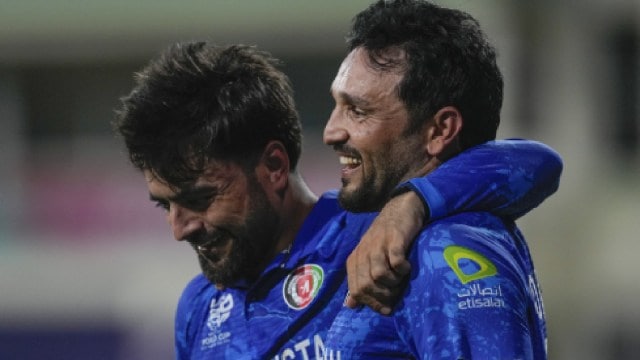 Afghanistan's captain Rashid Khan (left) embraces teammate Gulbadin Naib as they celebrate after defeating Bangladesh by eight runs in their T20 World Cup cricket match at Arnos Vale Ground, Kingstown, Saint Vincent and the Grenadines. (AP Photo)