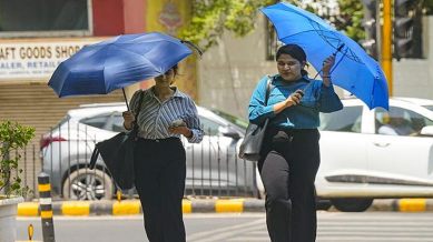 Women cover themselves under umbrellas during heatwave, in New Delhi, India Saturday, June 15, 2024.