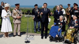 France's President Emmanuel Macron speaks after awarding 104-years-old British World War II veteran, Christian Lamb, who helped to plan the D-Day landings in Normandy