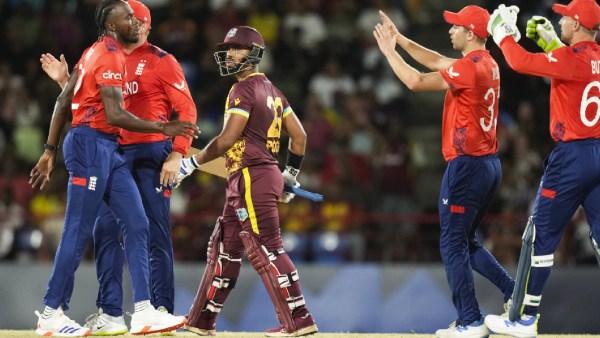 England's Jofra Archer, left, is congratulated by teammates after dismissing West Indies' Nicholas Pooran, centre, during the men's T20 World Cup cricket match between England and the West Indies at Darren Sammy National Cricket Stadium, Gros Islet, St Lucia, Wednesday, June 19, 2024. (AP Photo)