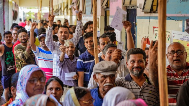 People show their identity cards as they wait in a queue to cast vote at a polling station under East Delhi constituency during the sixth phase of Lok Sabha elections, in New Delhi, Saturday, May 25, 2024. (PTI Photo)