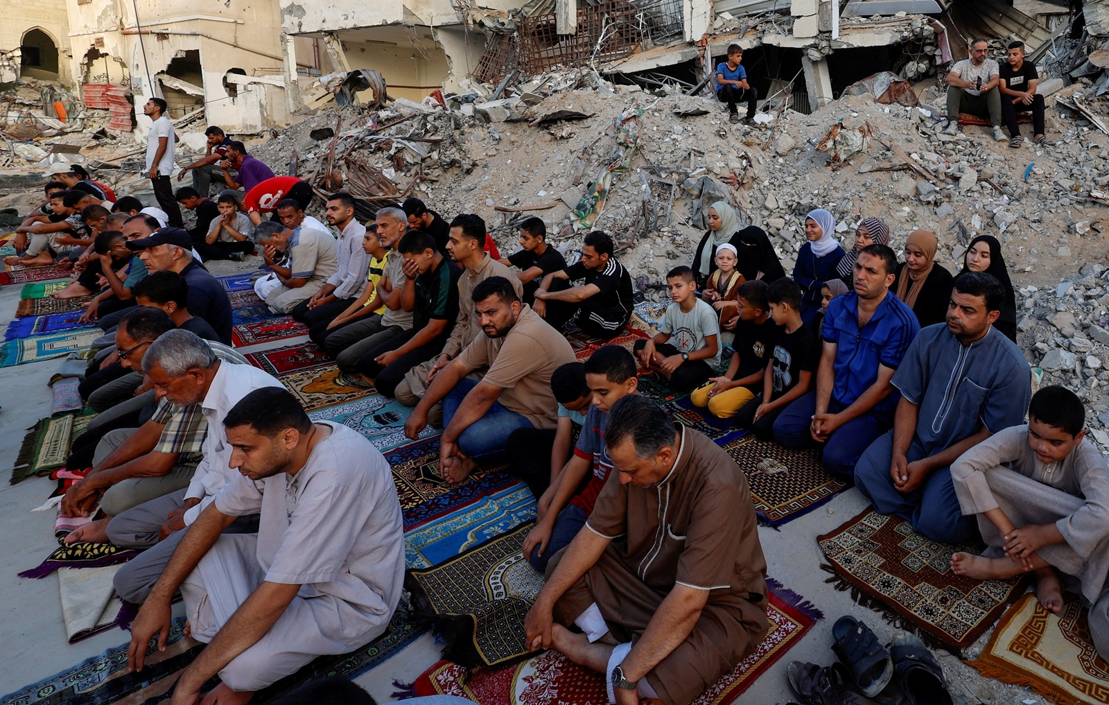 Palestinians hold Eid al-Adha prayers by the ruins of the Al-Rahma mosque destroyed by Israeli air strikes, in Khan Younis. (Reuters)