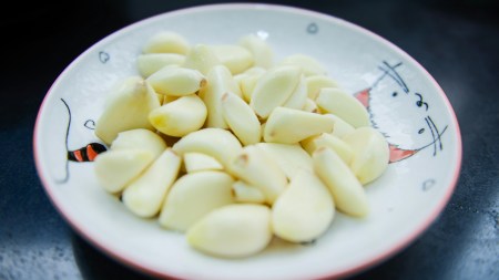 Can having 2 garlic cloves daily reduce both blood sugar and cholesterol?