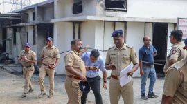 Police personnel at the site after a blast at an explosive-manufacturing factory, near Nagpu