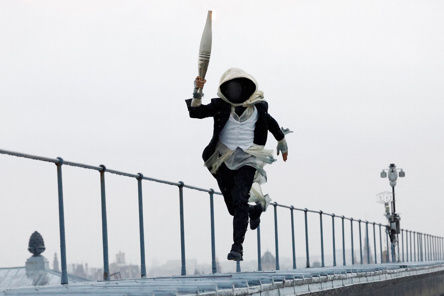 A torch bearer runs atop the Musee d’Orsay, in Paris, France, during the opening ceremony of the 2024 Summer Olympics, Friday, July 26, 2024. (AP/PTI)