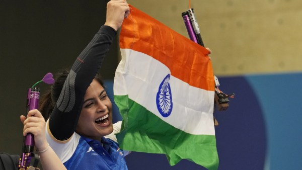 India's Manu Bhaker celebrates with the Indian flag after winning the bronze medal in the 10m air pistol women's final round at the 2024 Summer Olympics, Sunday, July 28, 2024, in Chateauroux, France. (AP Photo)