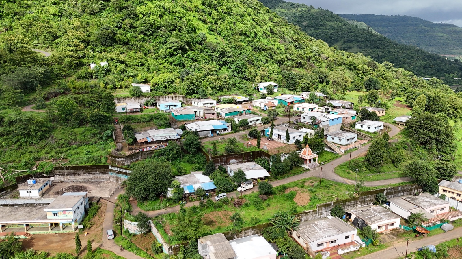 An aerial view of the rehabilitated Malin village about a kilometre from the original village which was destroyed by the landlide in 2014. The village has 68 homes and has facilities such as a village school, common cow shed, gram panchayat offices, temple and is guarded with compound walls. (Express Photo By Pavan Khengre)