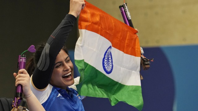 India's Manu Bhaker celebrates with the Indian flag after winning the bronze medal in the 10m air pistol women's final round at the 2024 Summer Olympics