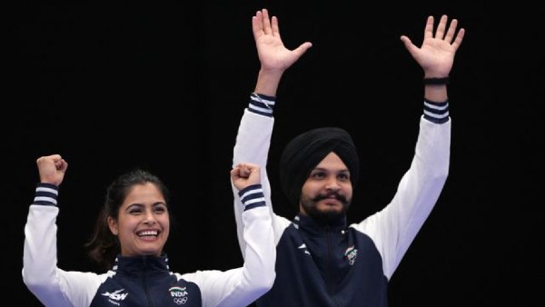  Bronze medallists Manu Bhaker of India and Sarabjot Singh (R) of India wave