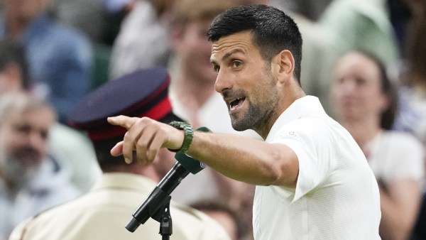 Novak Djokovic of Serbia gestures to the crowd as he is interviewed after defeating Holger Rune of Denmark in their fourth round match at the Wimbledon tennis championships in London