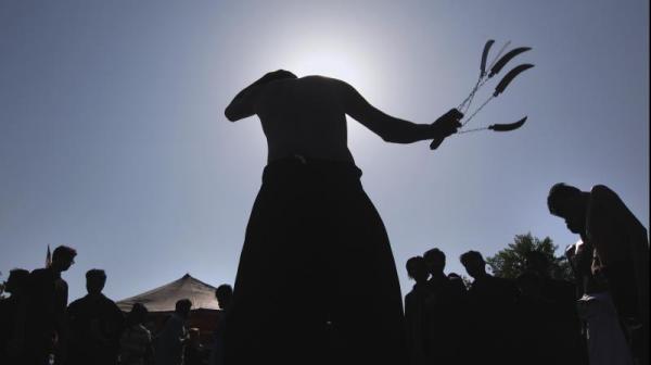 Muslims flagellates himself with knives on chains during a Muharram procession (AP)