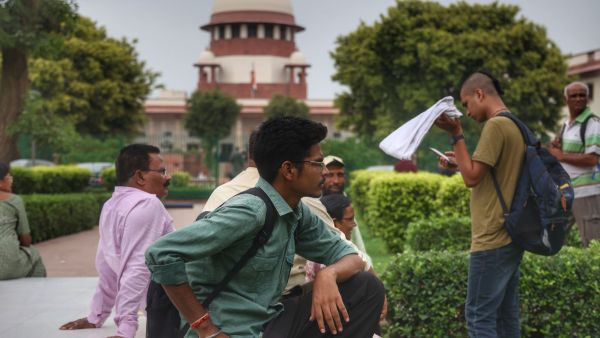 22 year old Piyush Pathak and others from Haryana, sit within the lawns of the supreme court during the hearing in the NEET paper leak case in New Delhi