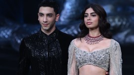 Khushi Kapoor graced the India Couture Week stage in a silver lehenga with an off-shoulder blouse, cape-styled sleeves and a mermaid skirt. Vedang Raina wore a black sherwani with elegant detailing and black pants.