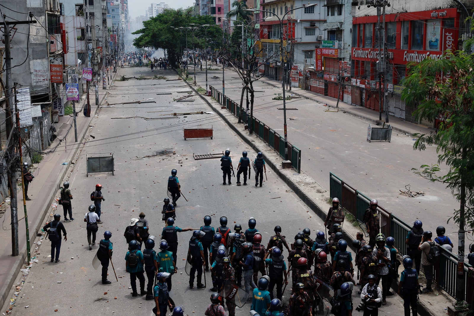 Members of Border Guard Bangladesh (BGB) and the police work to control the protesters outside the state-owned Bangladesh Television. (Reuters)