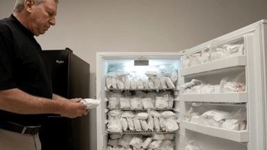 David Ayares, president and chief scientific officer of Revivicor, holds a package of frozen meat during an interview at the company’s offices in Blacksburg