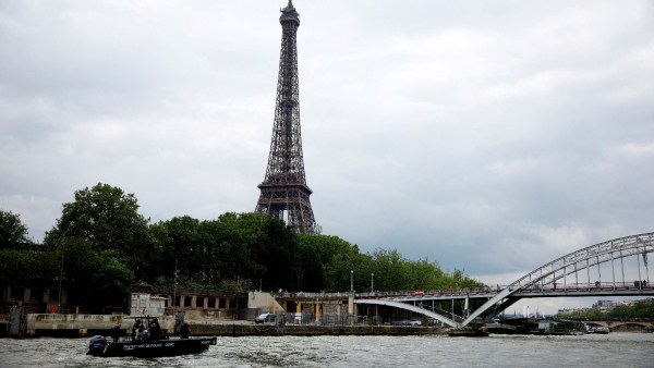 The Eiffel Tower is seen as police officers are pictured on the river Seine during the tour