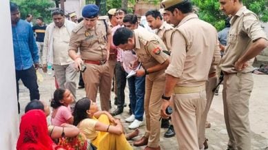 Police personnel outside a hospital where victims of the Hathras' stampede are admitted, in Etah, Tuesday