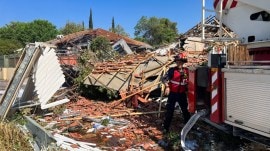 A firefighter works at the site of a house that was damaged after rockets were fired from Lebanon, in Katzrin in the Israeli-occupied Golan Heights