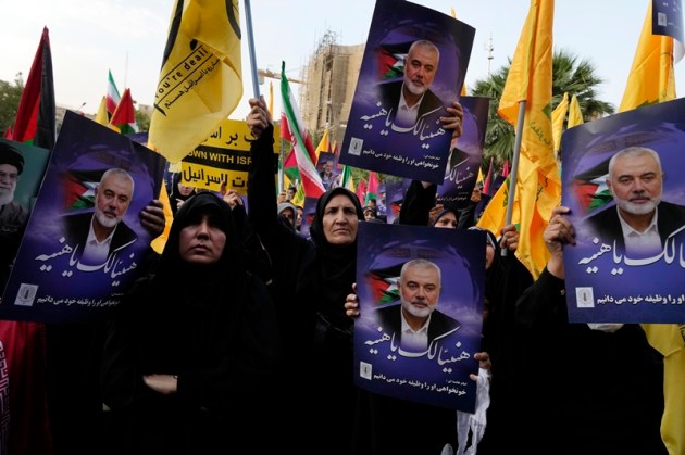 Iranian protesters attend a demonstration to condemn the killing of Hamas leader Ismail Haniyeh as they hold his posters with signs which read in Arabic: "Congratulations Haniyeh!" at Felestin (Palestine) Sq. in Tehran, Iran, Wednesday, July 31, 2024.