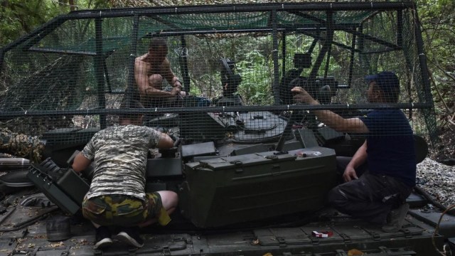 Soldiers of Ukraine's 65th Separate Mechanised Brigade install electronic warfare equipment on a tank on the frontline in Zaporizhzhia region, Ukraine