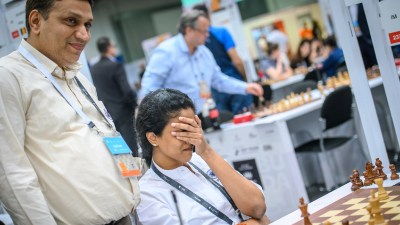 Harika Dronavalli reacts after securing her win in Round 11 of the Chess Olympiad while team captain Abhijit Kunte congratulates her. (PHOTO: FIDE / Michal Walusza)