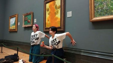 FILE - This photo provided by Just Stop Oil shows two protesters who have thrown tinned soup at Vincent Van Gogh's famous 1888 work Sunflowers at the National Gallery in London, Oct. 14, 2022. (Just Stop Oil via AP)