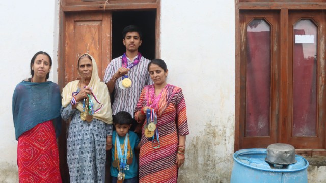 Archer Rakesh Kumar's mother Darshana Devi along with his wife Jyoti Devi and son Vansh Verma (boy in white) at their village Natali near Katra. (Express Photo by Kamleshwar Singh)