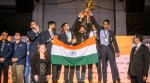 Viswanathan Anand (right) watches on as Indian men team celebrates at the podium after winning 2024 Chess Olympiad. (Michal Walusza | FIDE)