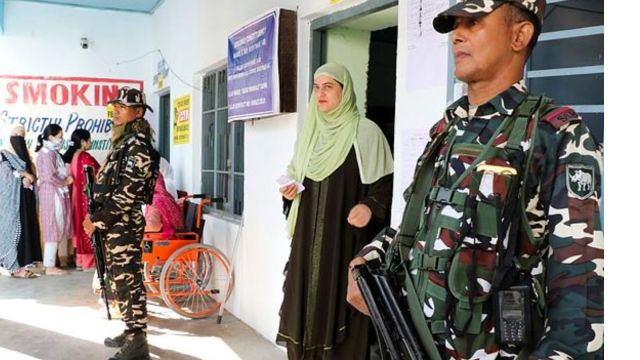 ecurity personnel stand guard as a voter leaves a polling booth after casting vote at a polling station during the first phase of Jammu and Kashmir Assembly elections, in Kishtwar district