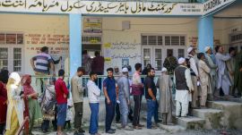 Voters stand in a queue to cast votes at a polling station during the first phase of Jammu and Kashmir Assembly elections, in Anantnag district of J&K
