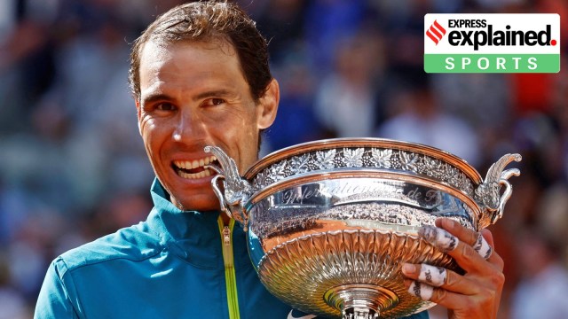 Spain's Rafael Nadal bites the trophy to observe  winning the 2022 French Open men's singles final.