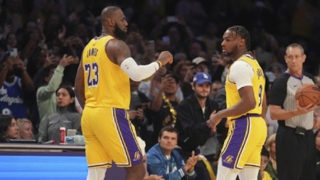 Los Angeles Lakers forward LeBron James (23) and guard Bronny James (9) stand on the court during the first half of an NBA basketball game against the Minnesota Timberwolves, Tuesday, Oct. 22, 2024, in Los Angeles. (AP Photo)