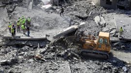 Rescue workers use a bulldozer to remove rubble of destroyed buildings, as they search for victims at the site that was hit by Israeli airstrikes in Qana village, south Lebanon, Wednesday, Oct. 16, 2024. (AP Photo/Mohammed Zaatari)