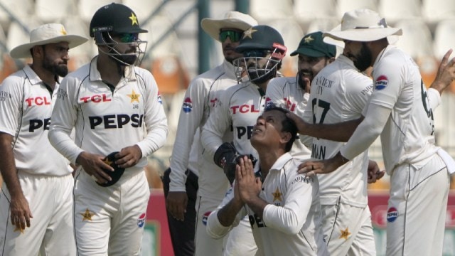 Pakistan's Noman Ali, halfway  bottom, celebrates arsenic  helium  is congratulated by teammates aft  helium  took his 5th  wicket (AP)