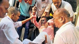A man being taken to the hospital after he consumed suspected spurious liquor, in Siwan district,