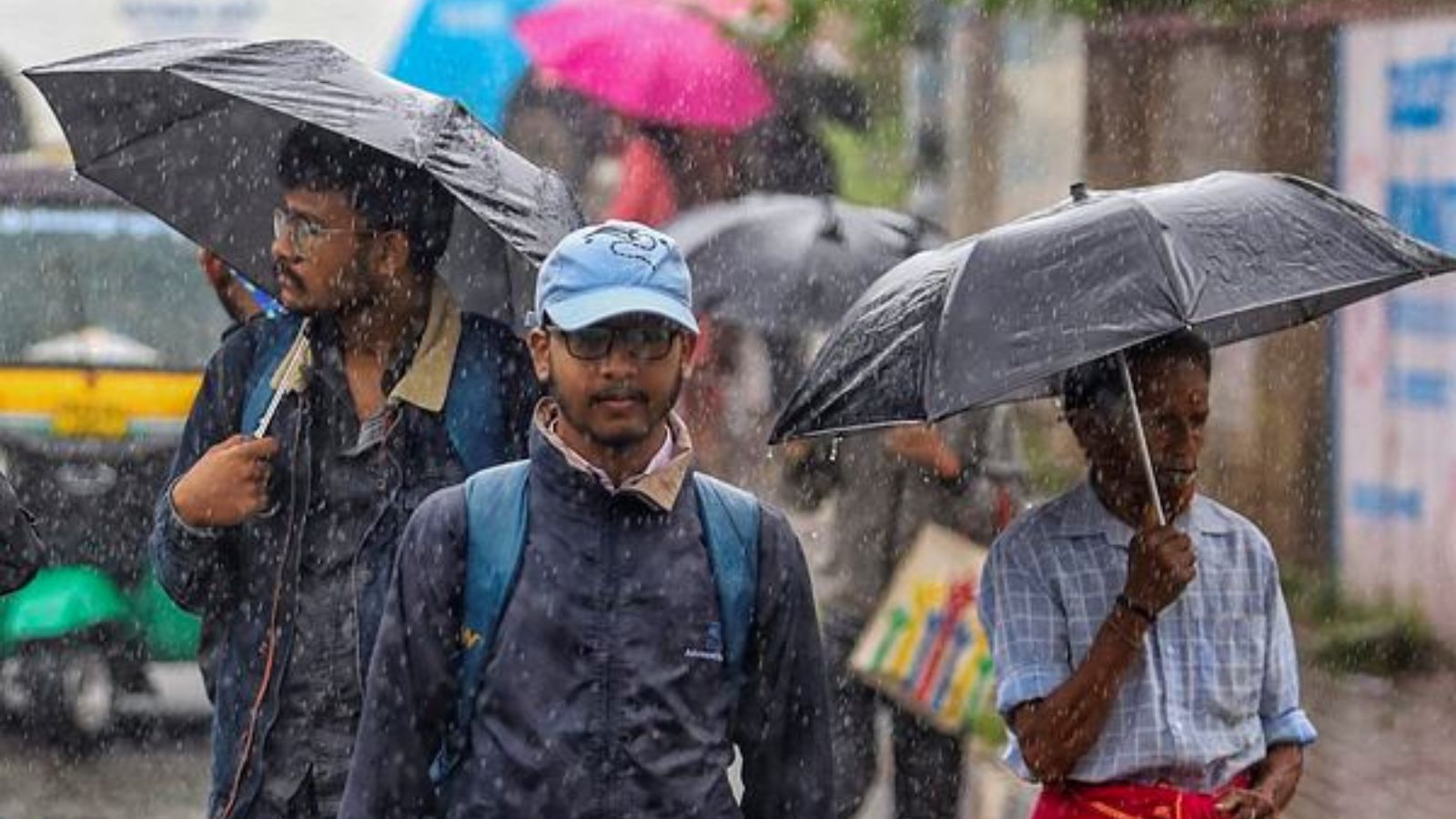 People holding umbrellas commute amid rains due to ‘Spawn’ cyclone, in Bengaluru